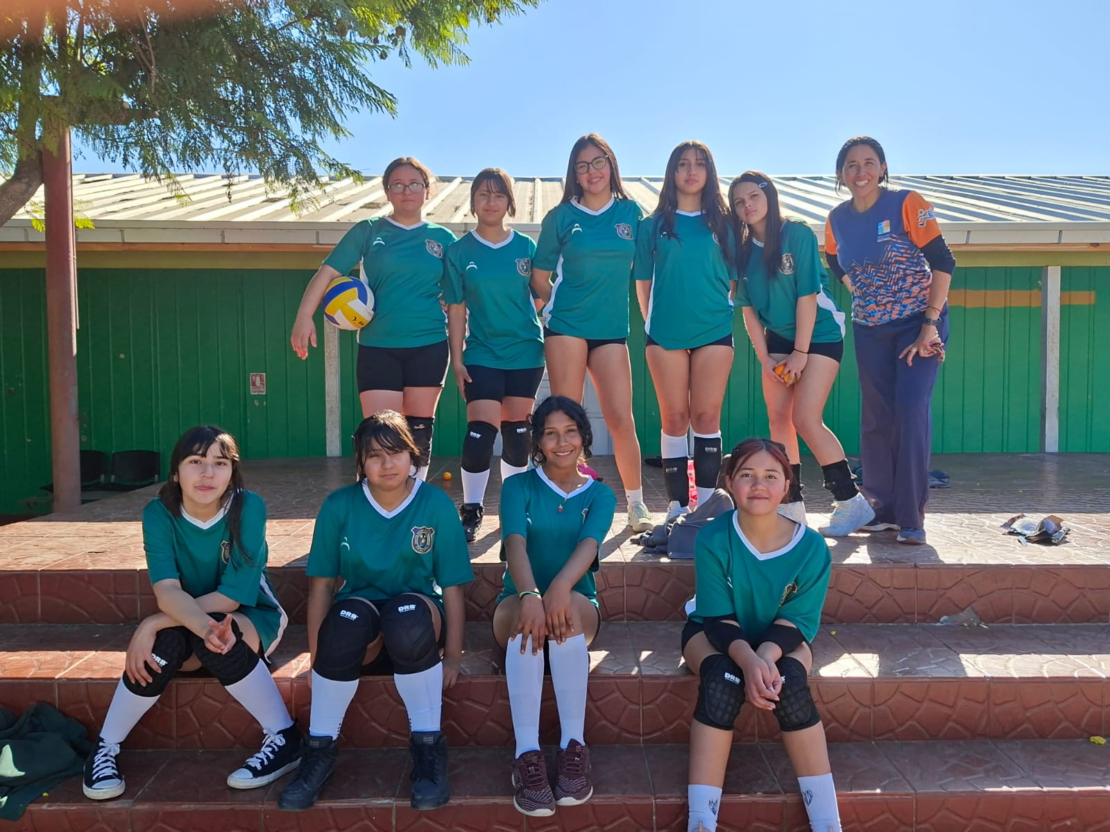 Selección de vóleibol femenino con su entrenadora